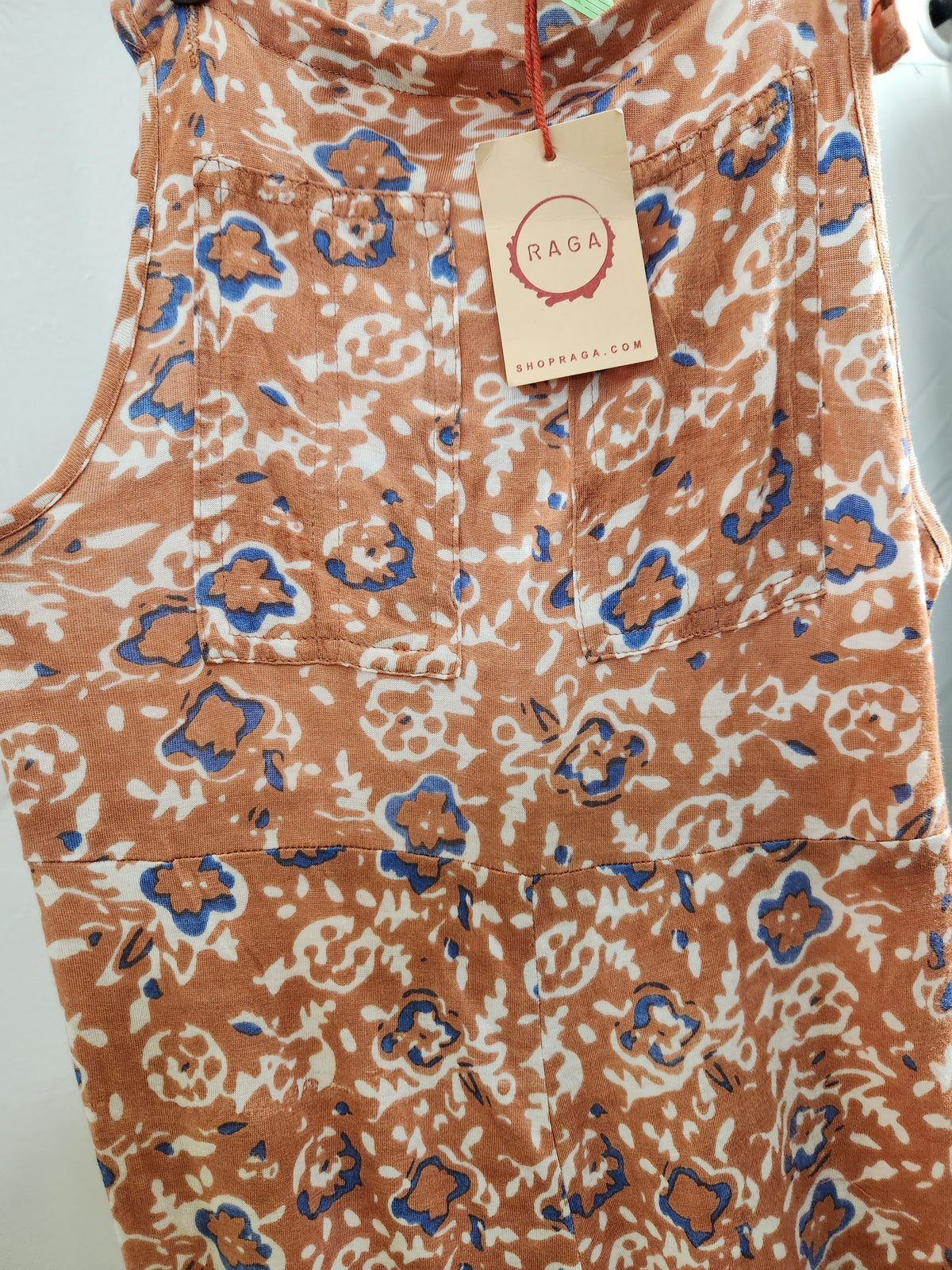 A sleeveless top or dress with an abstract floral pattern in terracotta orange, blue, and off-white. A beige paper hangtag with the brand name 'RAGA' is attached at the neckline.