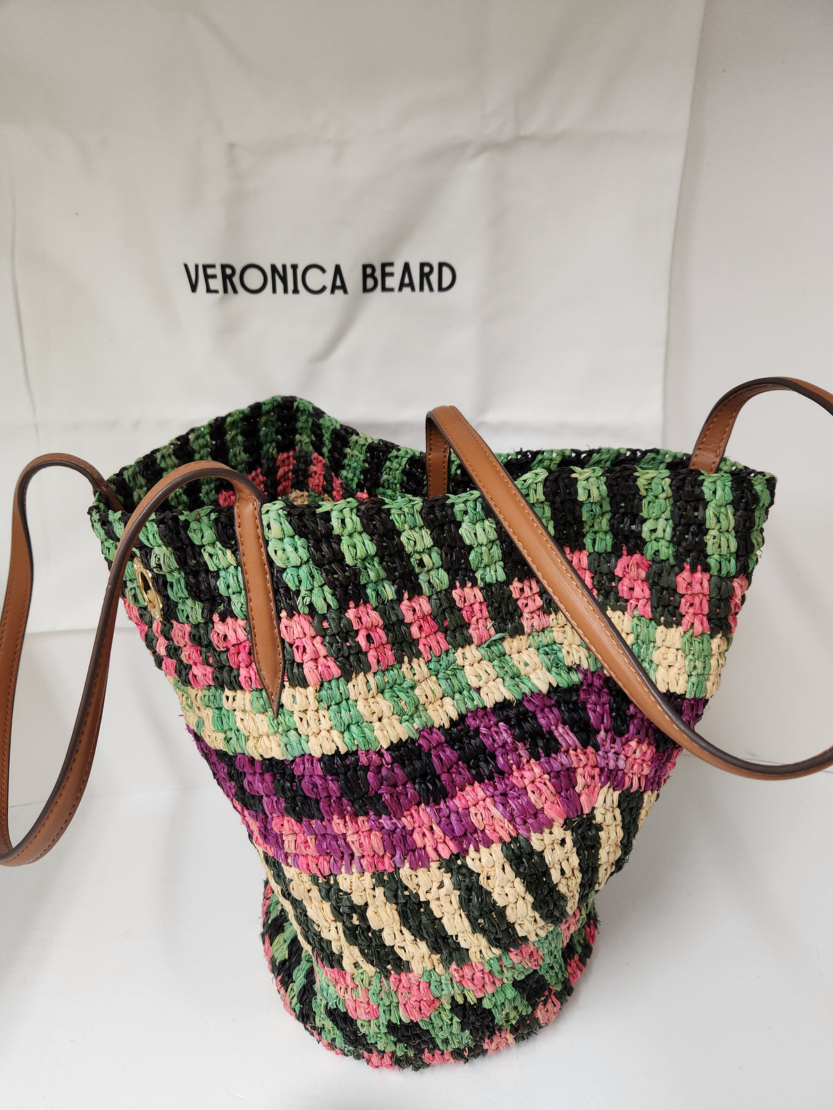 Veronica Beard Striped Raffia tote bag or anchor basket tote. A hand-woven multi-colored raffia body with dual brown leather top shoulder handles and a small golden medallion toggle closure at the top. Dust Bag included