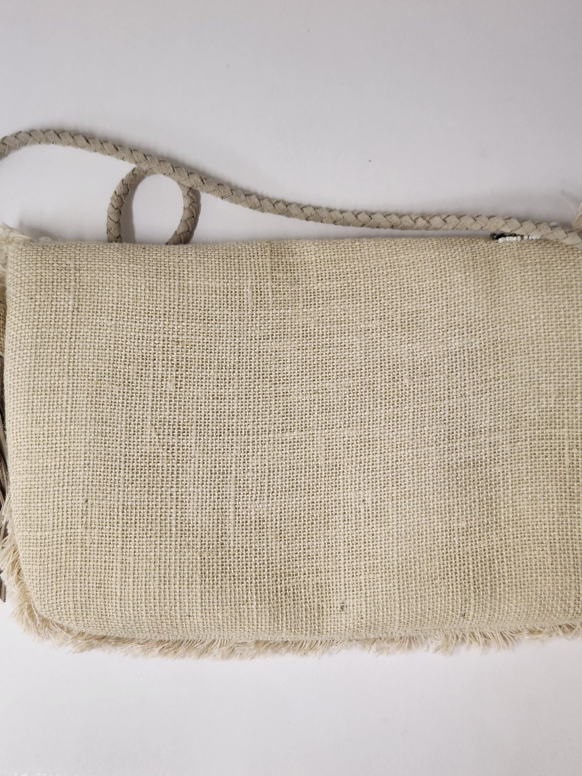 A natural beige woven burlap clutch bag with a braided rope handle and shoulder strap, shown against a plain white background.