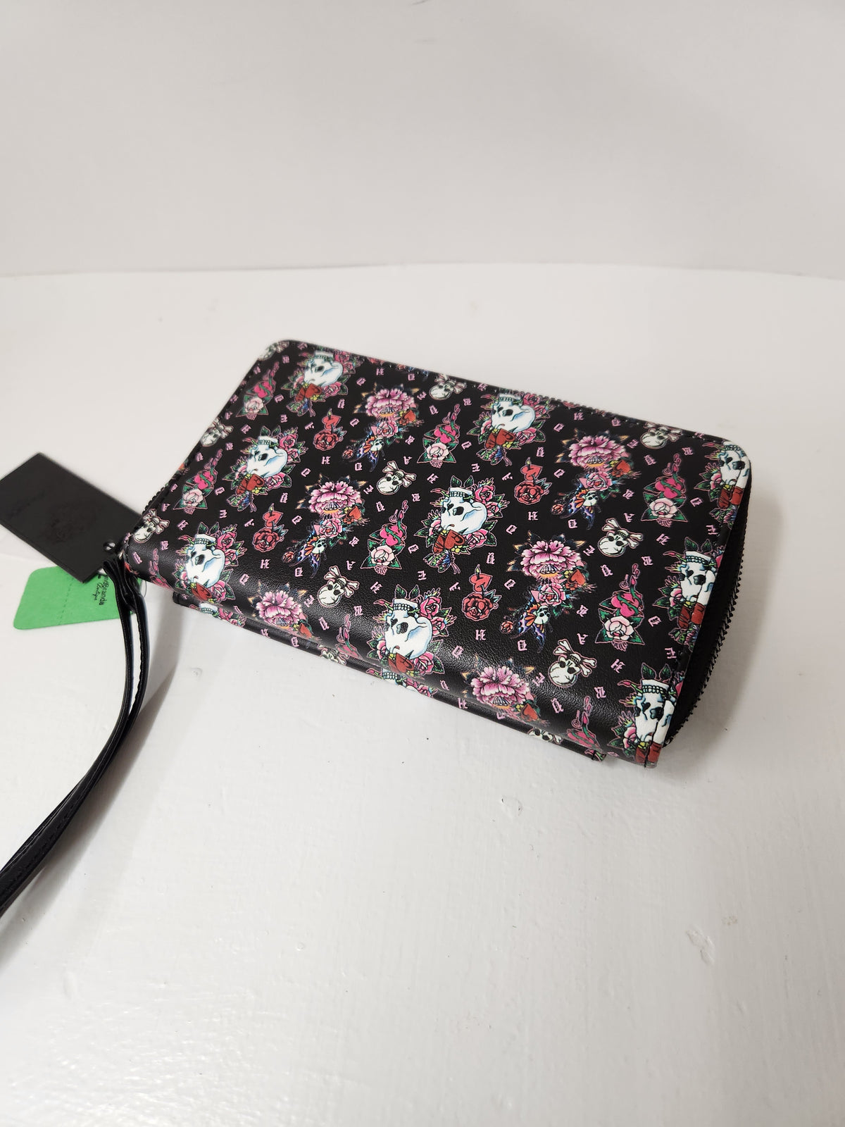 Ed Hardy Skull and Rose Tattoo Print Wallet feature a classic Y2K-inspired tattoo graphic pattern with skulls and pink flowers, complete with a silver metallic Ed Hardy brand logo plate on the front.