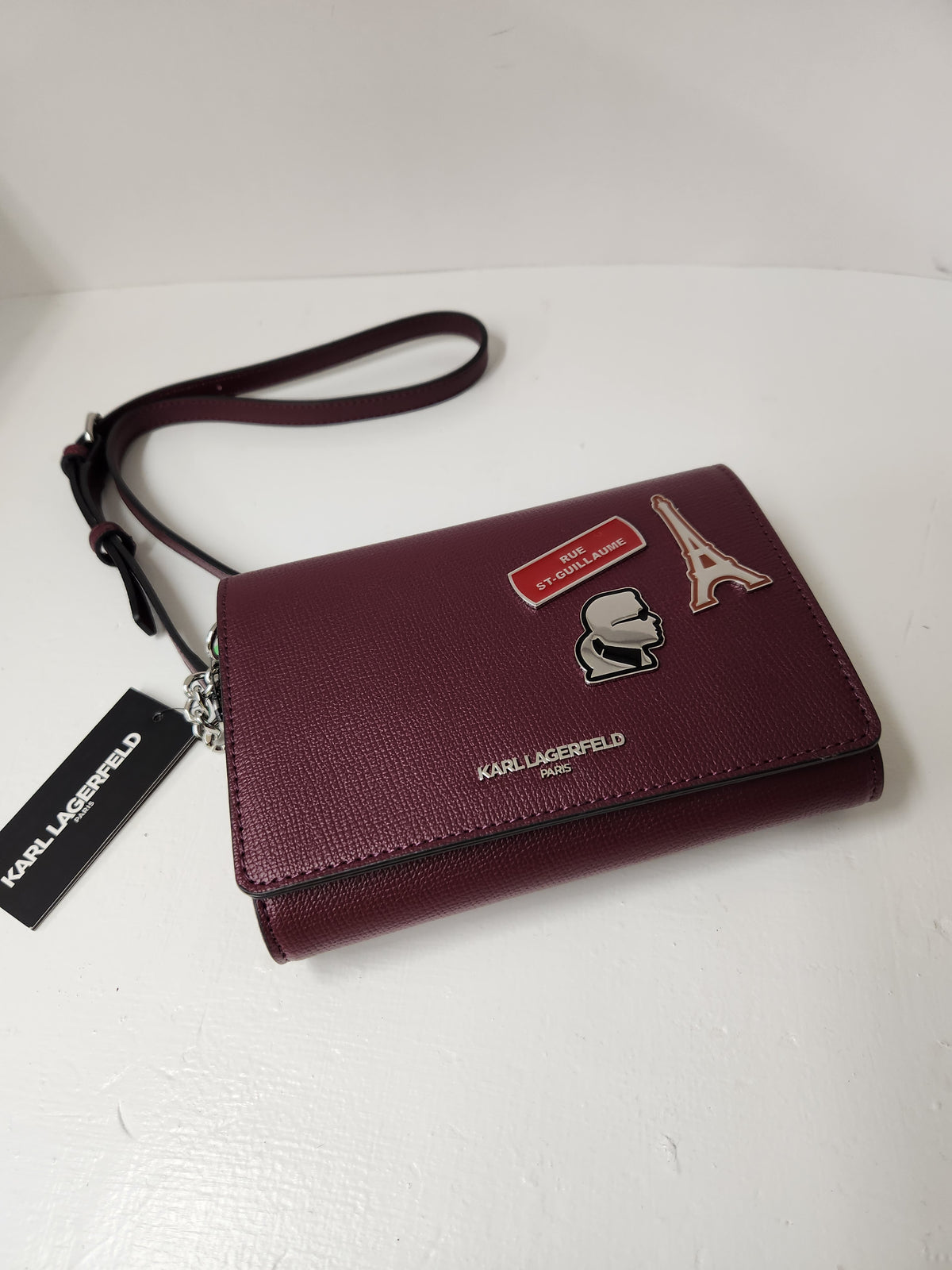Karl Lagerfeld Paris Essential Maison Crossbody Bag designed as a compact wallet-on-chain style bag, it functions as an organized crossbody purse featuring an interior setup typically equipped with card slots, a center zipper pocket, and storage options meant for carrying daily essentials.