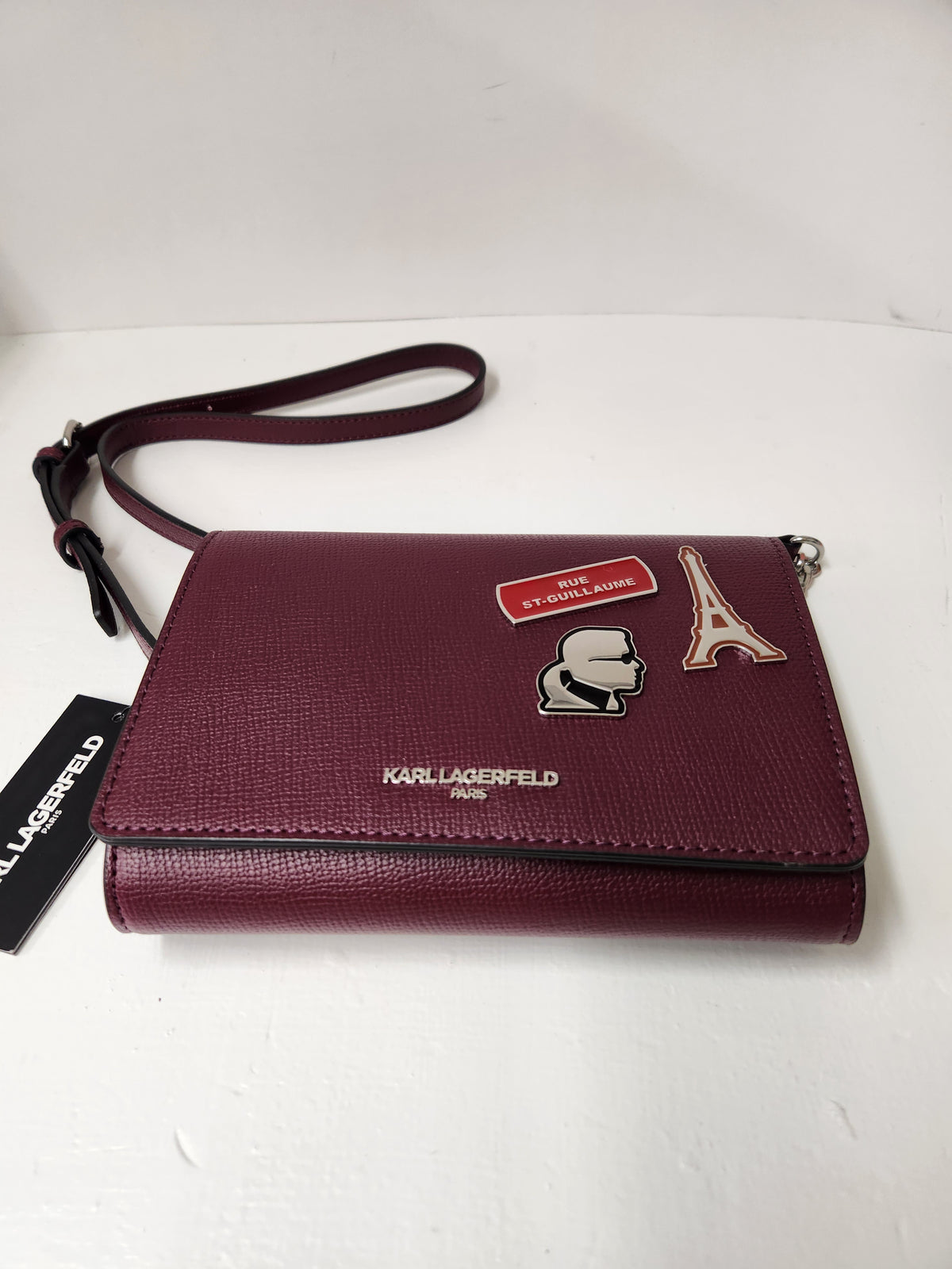 Karl Lagerfeld Paris Essential Maison Crossbody Bag designed as a compact wallet-on-chain style bag, it functions as an organized crossbody purse featuring an interior setup typically equipped with card slots, a center zipper pocket, and storage options meant for carrying daily essentials.