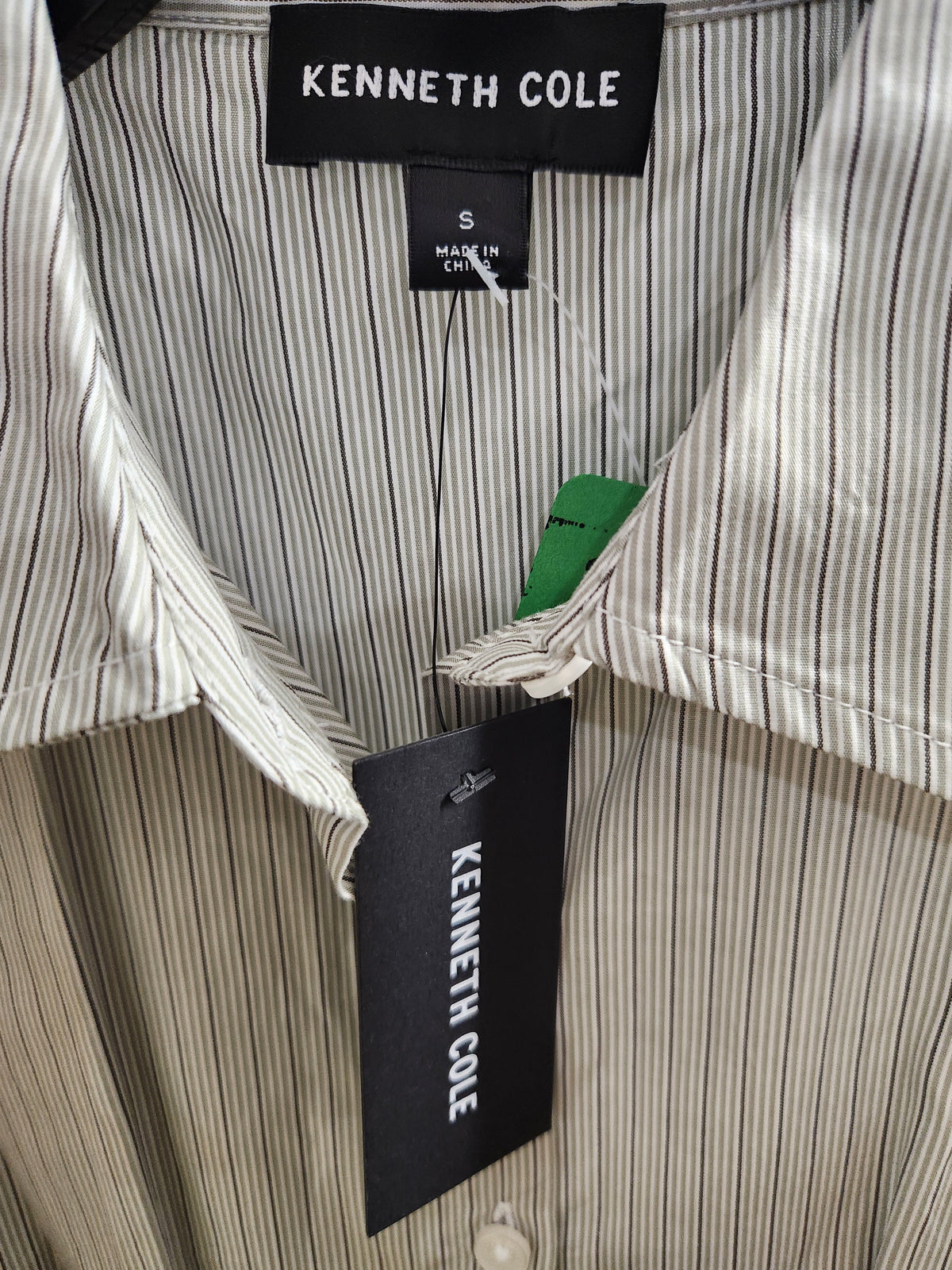 Close-up of a Kenneth Cole striped button-down shirt collar with a black brand label and a green size tag.