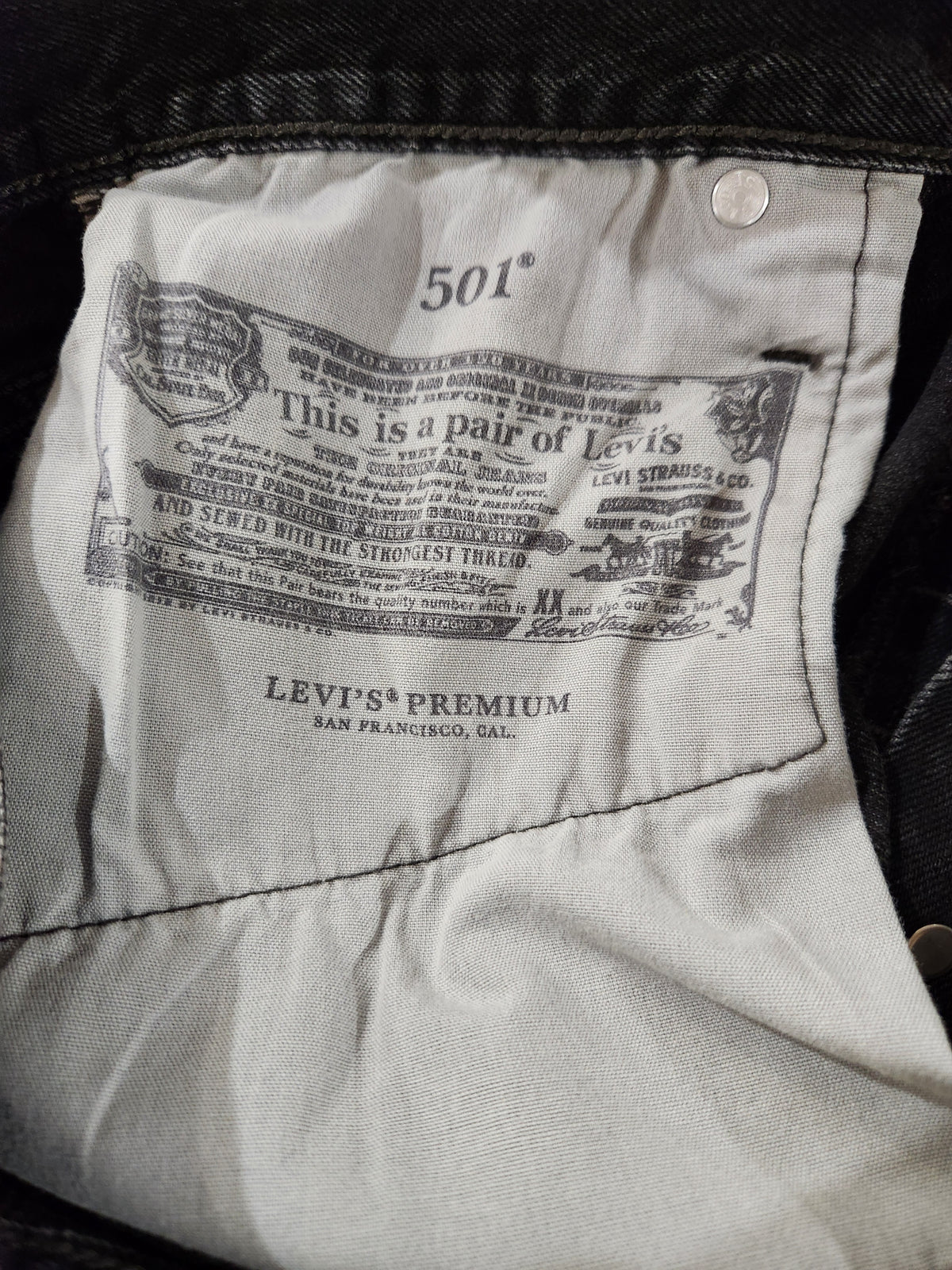 Close-up of the interior label of a pair of Levi's jeans, showing the brand name 'Levi's' and size '501' on the light gray fabric lining.