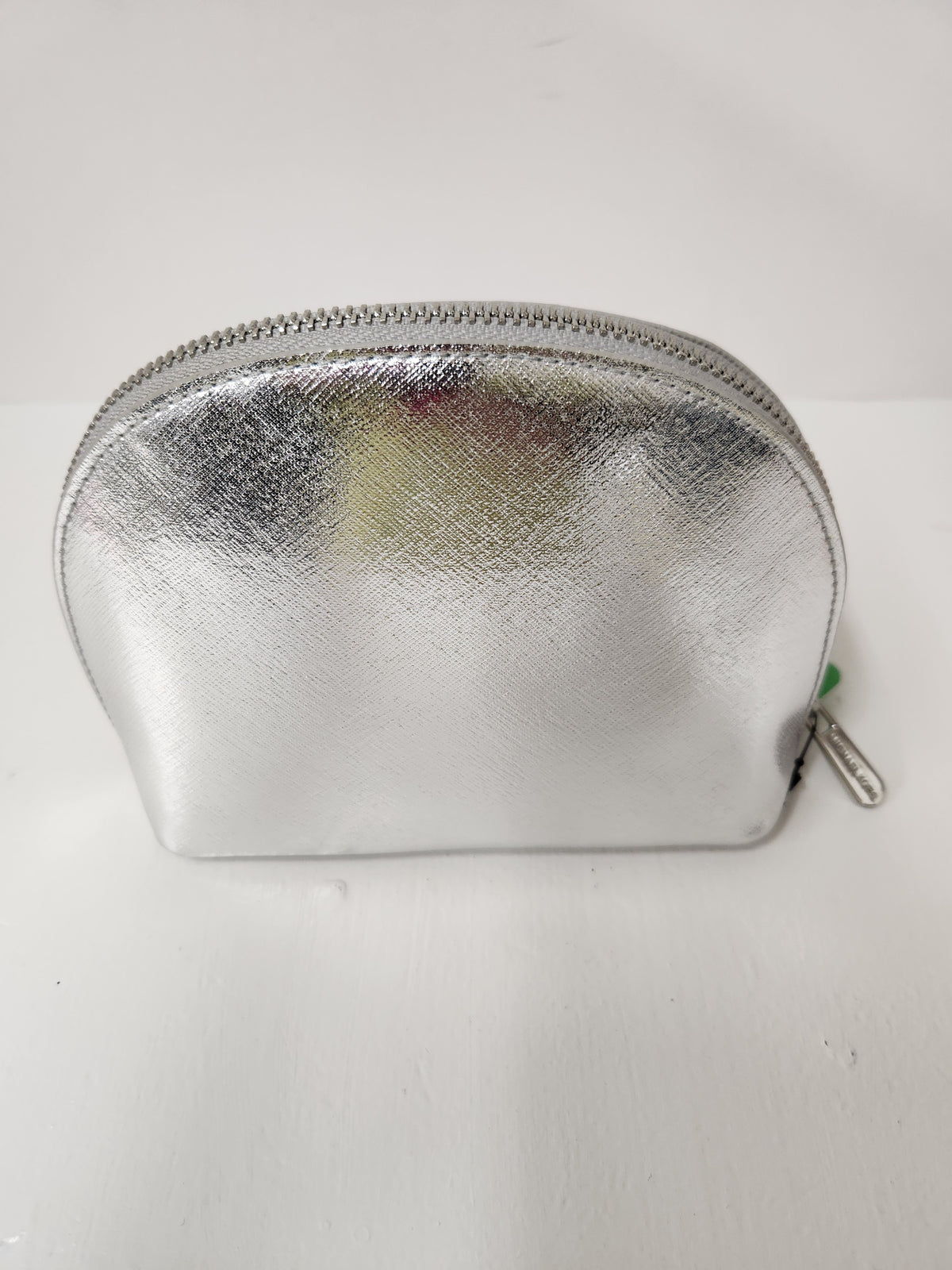 A small metallic silver zippered cosmetic pouch with a textured leather-like finish, photographed on a plain white background.