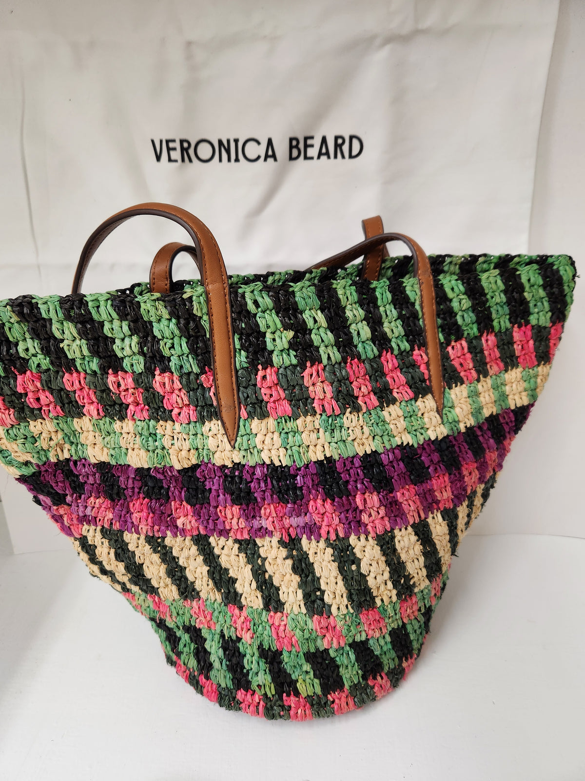 Veronica Beard Striped Raffia tote bag or anchor basket tote. A hand-woven multi-colored raffia body with dual brown leather top shoulder handles and a small golden medallion toggle closure at the top. Dust Bag included