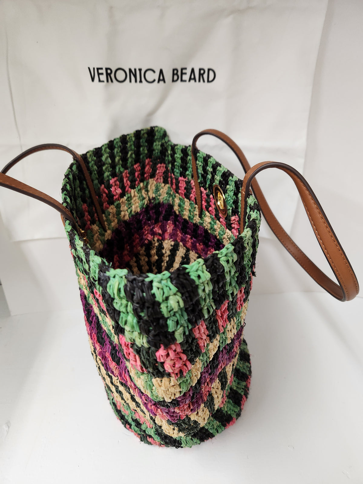 Veronica Beard Striped Raffia tote bag or anchor basket tote. A hand-woven multi-colored raffia body with dual brown leather top shoulder handles and a small golden medallion toggle closure at the top. Dust Bag included