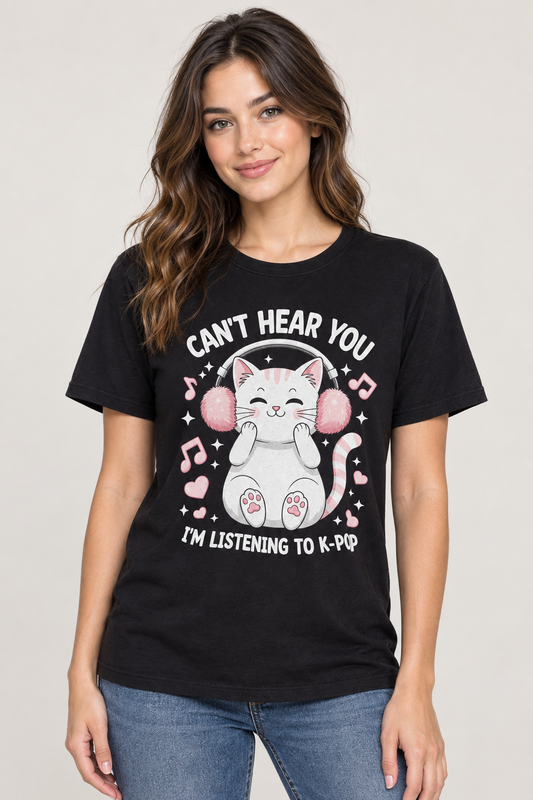 A woman wearing a black graphic t-shirt with a cartoon cat wearing pink headphones and the text 'CAN'T HEAR YOU I'M LISTENING TO K-PAP'.